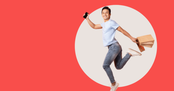 man running with shopping bags in one hand and a mobile phone in the other